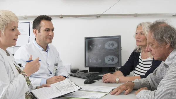 Arztegespräch, © Krebsinformationsdienst, DKFZ; Foto: Tobias Schwerdt Ein Patient mit Lungenkrebs und seine Angehörige im Gespräch mit zwei Ärzten.