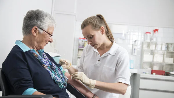 Blutabnahme, © Tobias Schwerdt; Krebsinformationsdienst, DKFZ Eine Arzthelferin nimmt einer Patientin Blut ab.
