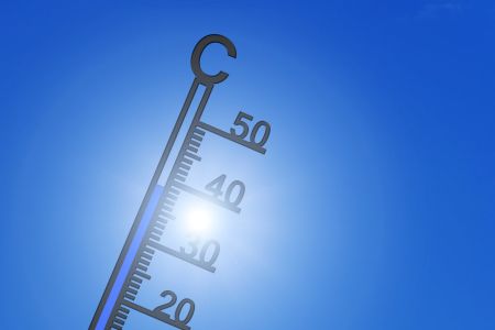 Thermometer mit Sonne im Hintergrund