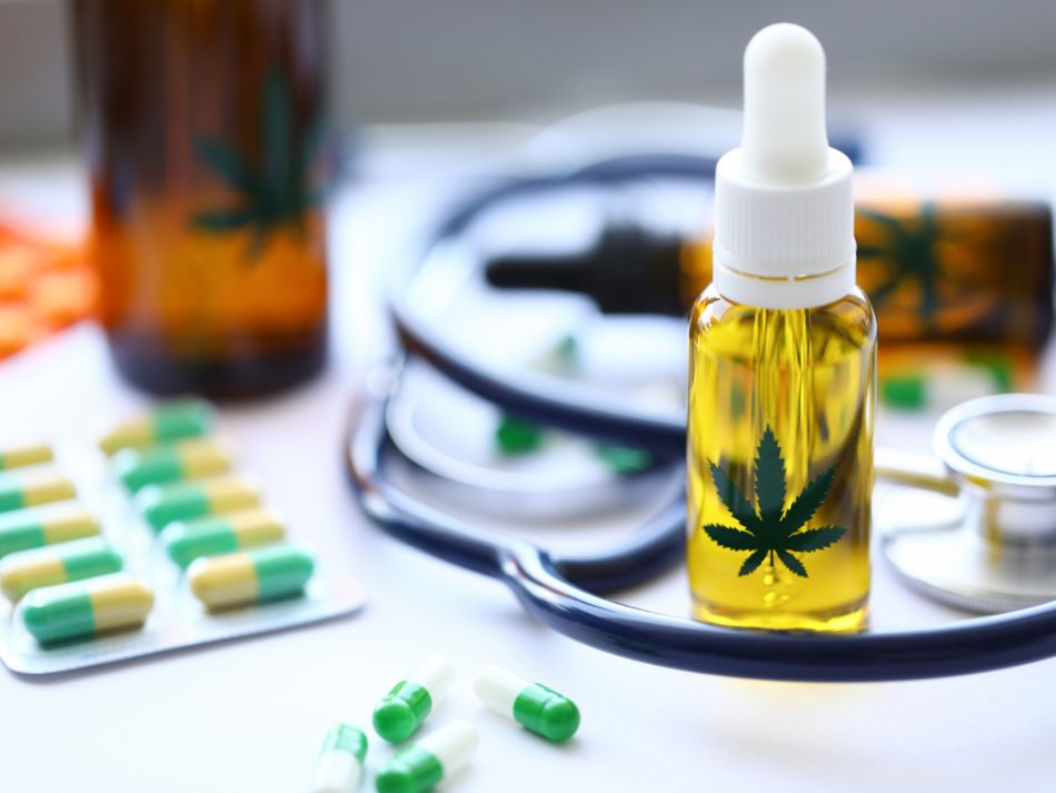 Kapseln, Tropffläschchen mit einem abgebildeten Cannabisblatt und Stethoskop