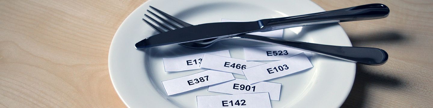 Auf einem Teller liegen Papierschnipsel mit E-Nummern darauf. © Krebsinformationsdienst, Deutsches Krebsforschungszentrum