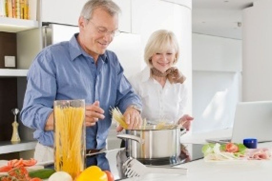 Mann und Frau beim Nudeln kochen.