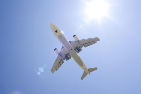 Flugzeug am blauen Himmel mit Sonne