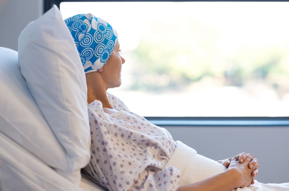 Frau mit Kopftuch in einem Krankenhausbett © Rido/shutterstock.com