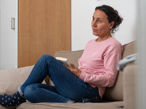 Nachdenkliche Frau sitzt auf dem Sofa © Krebsinformationsdienst, DKFZ