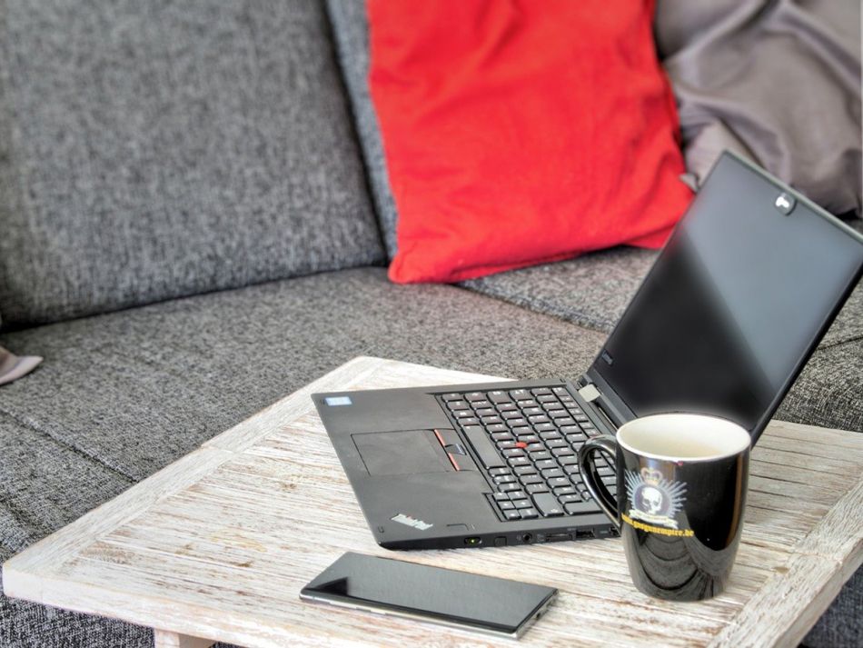 Laptop, Kaffeetasse und Handy im Homeoffice