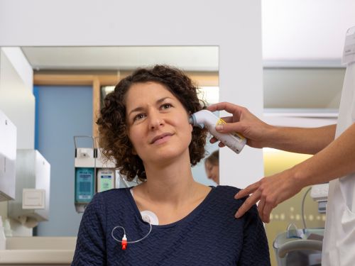 Patientin wird mit Ohrthermometer Fieber gemessen. Bild: Tobias Schwerdt © Krebsinformationsdienst, DKFZ