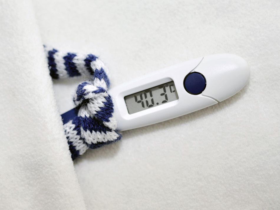Fieberthermometer, das 40,3° zeigt und mit einem Schal in einem winzigen Bett liegt © congerdesign, Pixabay