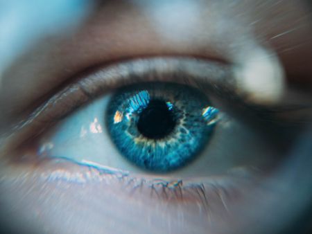 Auge mit blauer Iris in Nahaufnahme