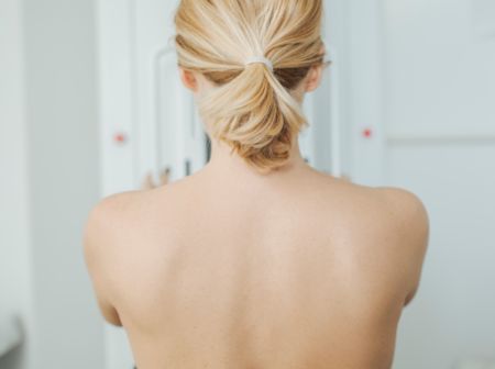 Rückenansicht einer Frau bei der Mammographie