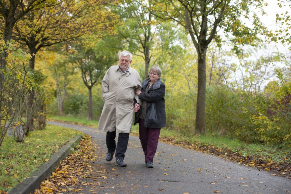 Ein älteres Paar geht im Park spazieren.