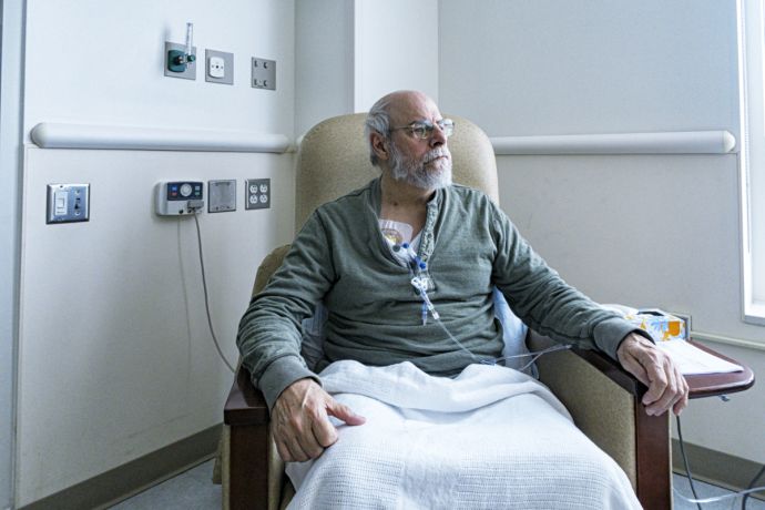 Mann sitzt in einem Krankenhausstuhl