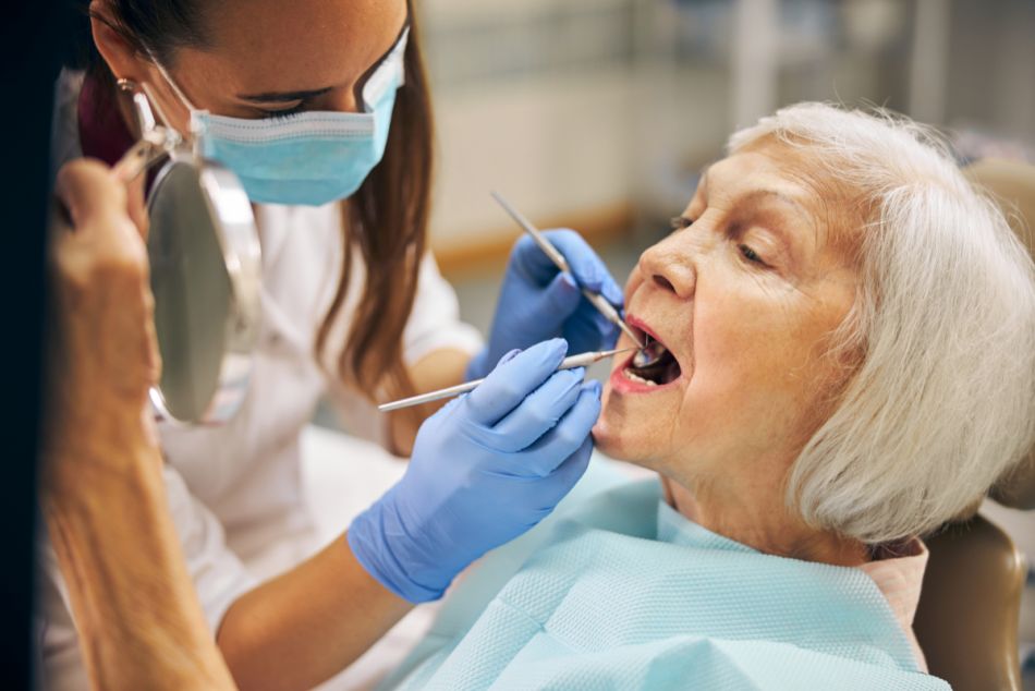 Eine Zahnärztin untersucht die Zähne einer Krebspatientin