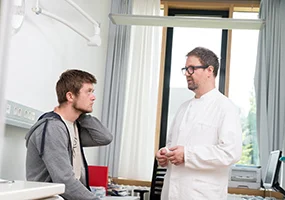 Junger Patient mit Arzt beim Aufklärungsgespräch im Krankenhaus. Foto: Tobias Schwerdt Junger Patient mit Arzt beim Aufklärungsgespräch im Krankenhaus. Foto: Tobias Schwerdt