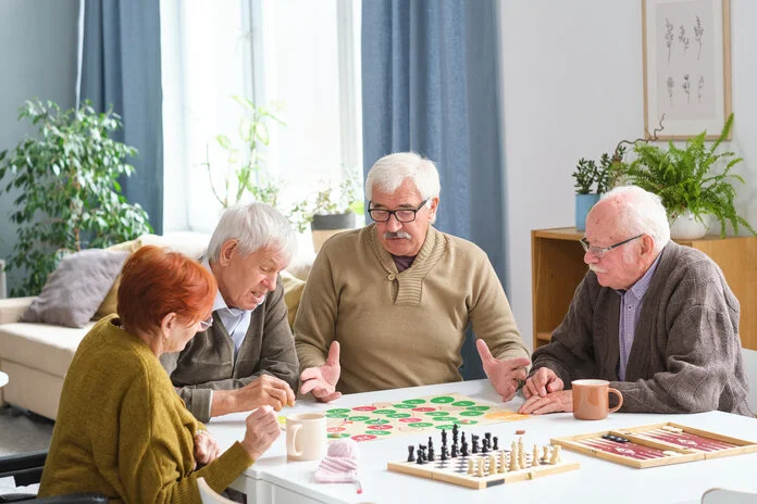 Eine Gruppe von älteren Menschen am Tisch beim Brettspiel