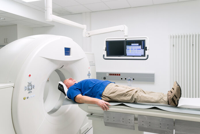 Computertomographie-Untersuchung, © Krebsinformationsdienst, DKFZ; Foto: Tobias Schwerdt Ein Mann liegt auf dem Untersuchungstisch eines Computertomographen.