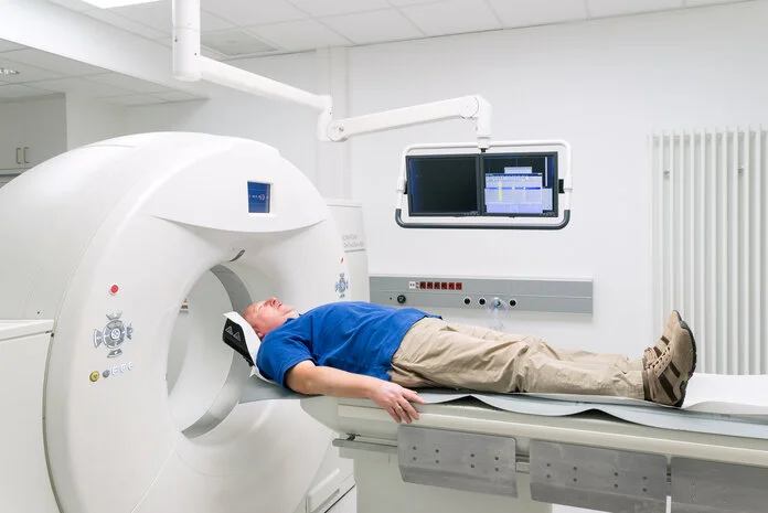 Computertomographie-Untersuchung, © Krebsinformationsdienst, DKFZ; Foto: Tobias Schwerdt Ein Mann liegt auf dem Untersuchungstisch eines Computertomographen.