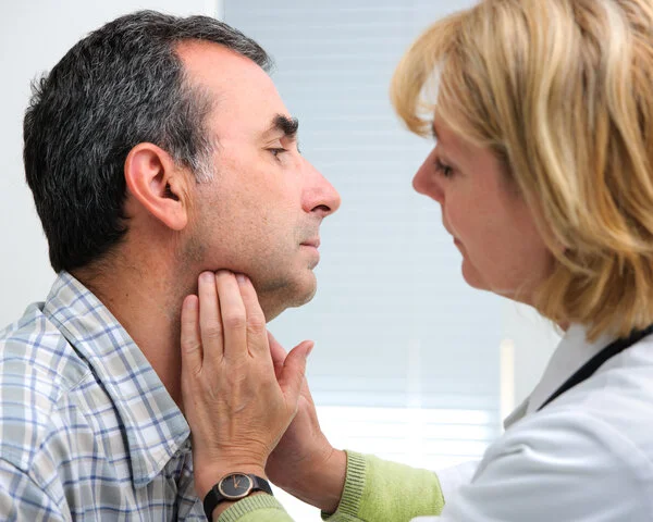 Halslymphknoten abtasten, © Alexander Raths, Shutterstock Äztin tastet einem Mann die Halslymphknoten ab