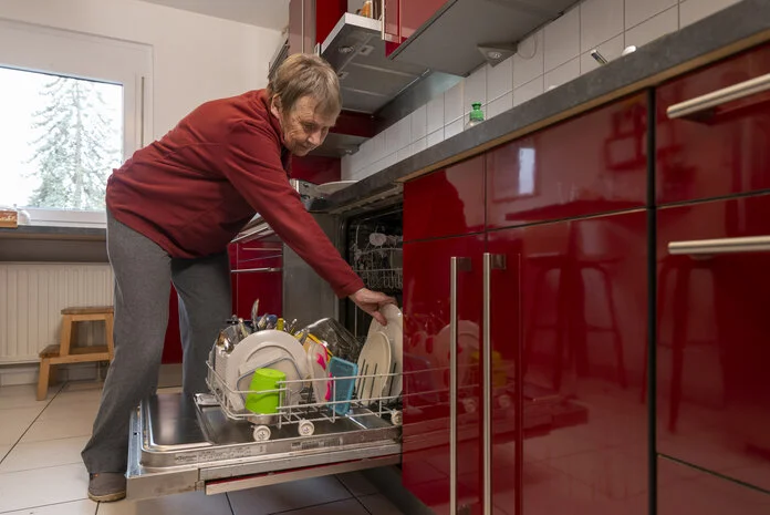 Hausarbeit, © Krebsinformationsdienst, DKFZ; Foto: Tobias Schwerdt Eine alte Frau räumt die Spülmaschine ein.