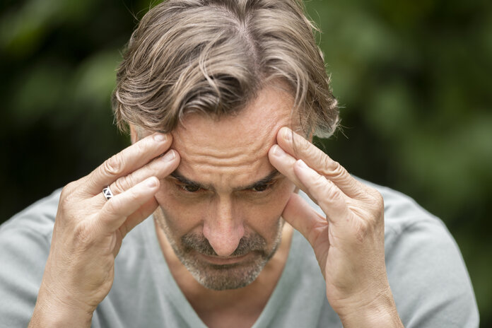 Mann stützt nachdenklich die Hände an den Kopf