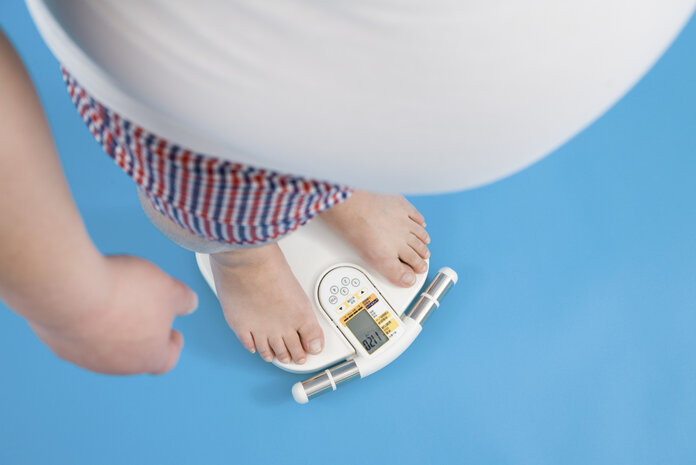 Körpergewicht, © Whitetag, Thinkstock Perspektive von oben: Mann mit größerem Bauchumfang steht auf einer Waage und wiegt sich.