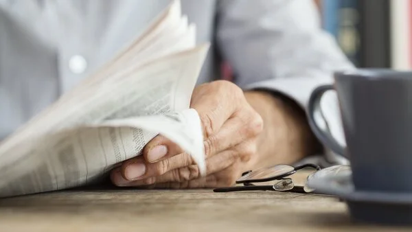 Zeitung lesen, © istock,seb_ra Mann sitzt mit Kaffeetasse am Tisch und liest Zeitung