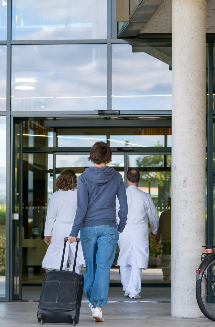 Frau betritt Krankenhaus, © Krebsinformationsdienst, DKFZ; Foto: Tobias Schwerdt Frau betritt Krankenhaus