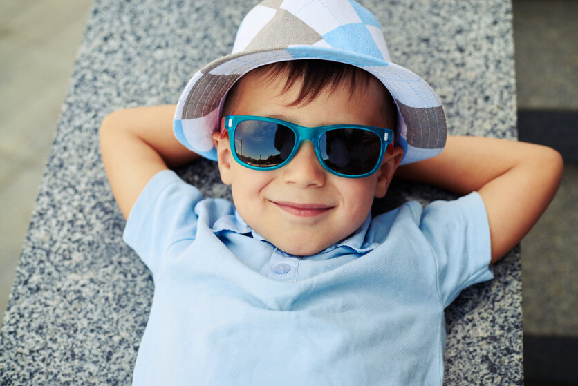 Kleiner Junge mit Sonnenbrille und Hut , ArtFamily, Shutterstock Ein kleiner Junge trägt eine Sonnenbrille und einen Hut und schaut in die Kamera.