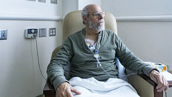 Patient, © Willowpix, iStock Mann sitzt in einem Krankenhausstuhl