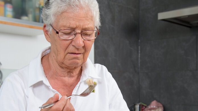 Appetitlosigkeit, © Krebsinformationsdienst, DKFZ; Foto: Tobias Schwerdt Ältere Frau sitzt am Esstisch und hat keinen Apetit beim Essen.