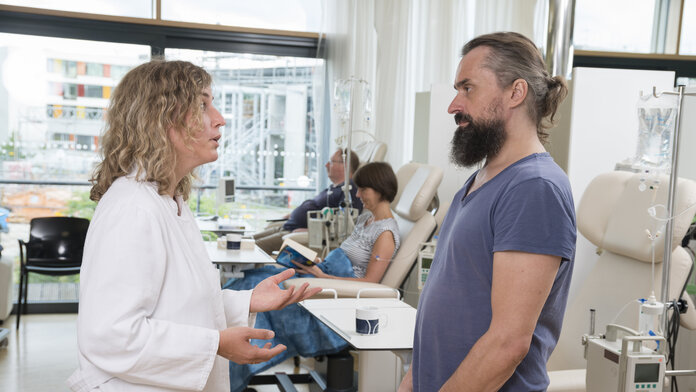 Ärztin spricht mit Patienten, © Krebsinformationsdienst, DKFZ; Foto: Tobias Schwerdt Eine Ärztin steht vor einem Patienten in einer Chemotherapie Ambulanz und spricht.