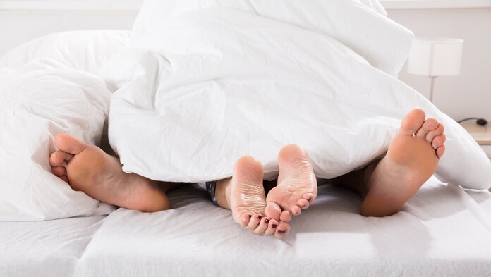 Sexualität, © Andrey Popov, IStockphoto.com Ein Paar im Bett unter der Bettdecke. Zu sehen sind ihre Füße.