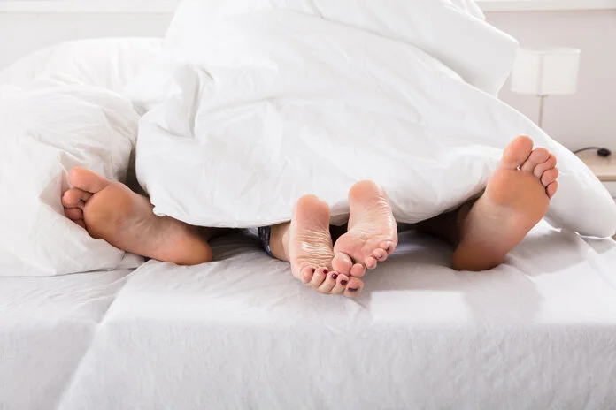Sexualität, © Andrey Popov, IStockphoto.com Ein Paar im Bett unter der Bettdecke. Zu sehen sind ihre Füße.