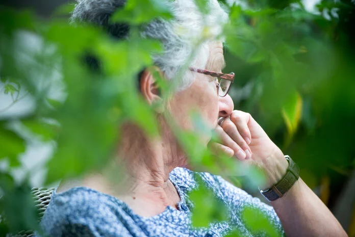 Nachdenkliche Frau, © Krebsinformationsdienst, DKFZ; Foto: Tobias Schwerdt Alte Frau sitzt nachdenklich im Garten.