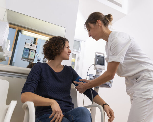 Krankenschwester misst bei Patientin Blutdruck