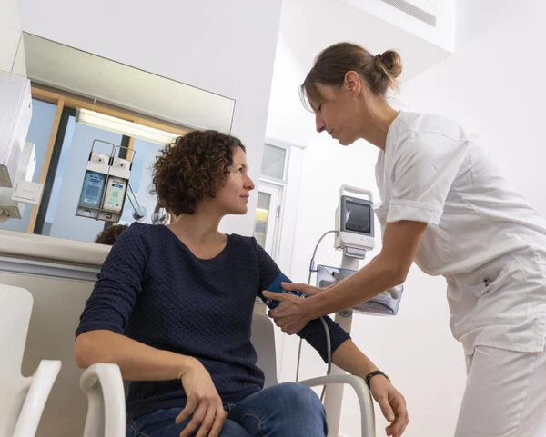 Blutdruck messen , © Krebsinformationsdienst, DKFZ Krankenschwester misst bei Patientin Blutdruck