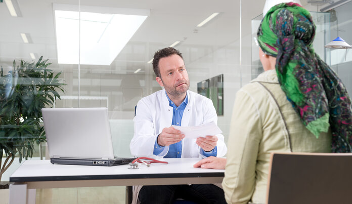Gespräch mit dem Arzt, © Krebsinformationsdienst, DKFZ; Foto: Tobias Schwerdt Arzt und Patientin sitzen an einem Tisch und führen ein Gespräch.