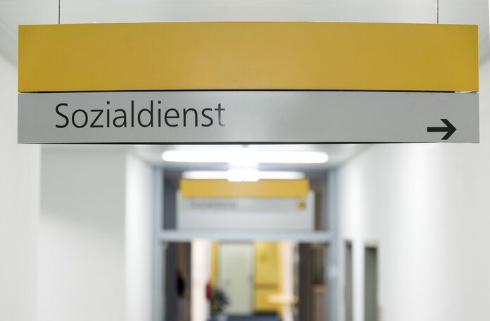 Schild "Sozialdienst", © Krebsinformationsdienst, DKFZ; Foto: Tobias Schwerdt Schild an der Decke eines Krankenhaus-Flurs mit der Aufschrift Sozialdienst