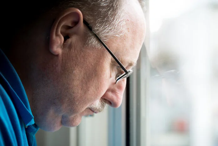 besorgter Mann, © Krebsinformationsdienst, DKFZ; Foto: Tobias Schwerdt Älterer Mann schaut mit besorgtem Blick aus dem Fenster.