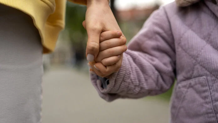 Mutter und Kind halten sich an der Hand, © Freepik Großaufnahme der Hand einer Frau, die die Hand eines Kindes hält.