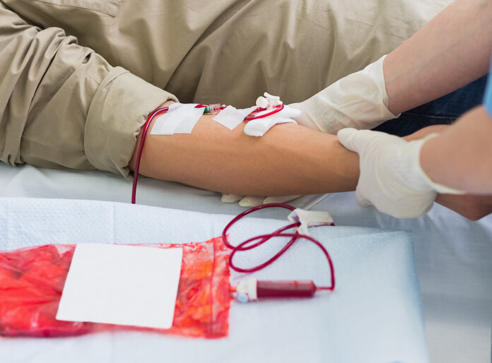 Ein männlicher Patient erhält eine Bluttransfusion in eine Armvene.