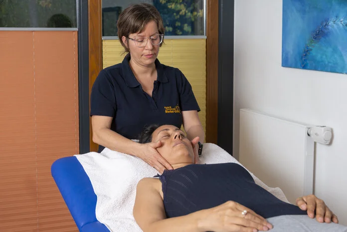 Massage, © Krebsinformationsdienst, DKFZ; Foto: Tobias Schwerdt Physiotherapeutin massiert eine liegende Frauam Hals.