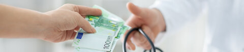 Arzt nimmt Geld entgegen.