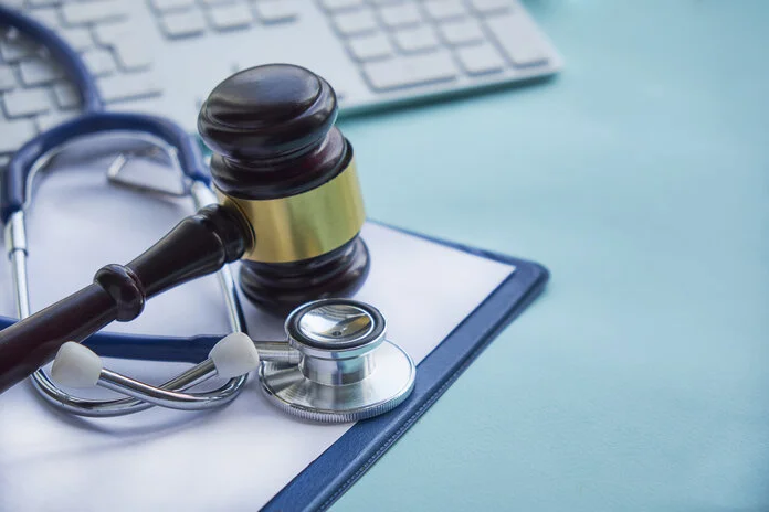 Hammer und Stethoskop, © yavdat, iStockphoto.com Hammer und Stethoskop liegen nebeneinander mit einer Computertastatur auf einem Bürotisch.