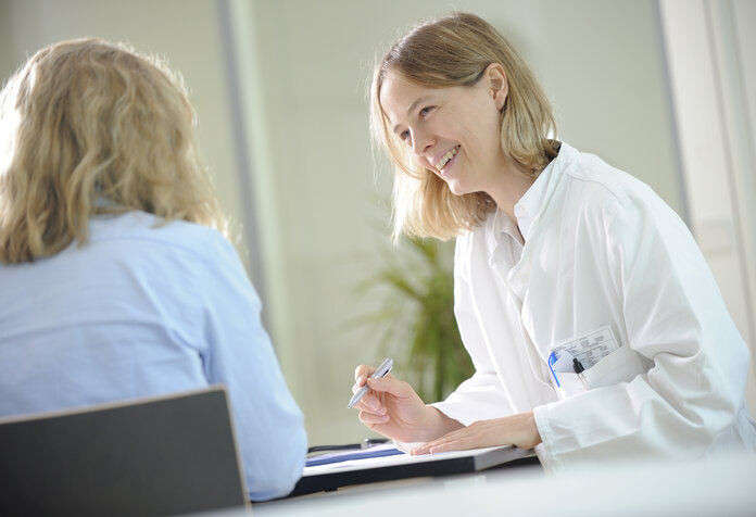 Arztgespräch, © Krebsinformationsdienst, DKFZ; Foto: Tobias Schwerdt Ärztin am Schreibtisch führt ein freundliches Gespräch mit einer Patientin.
