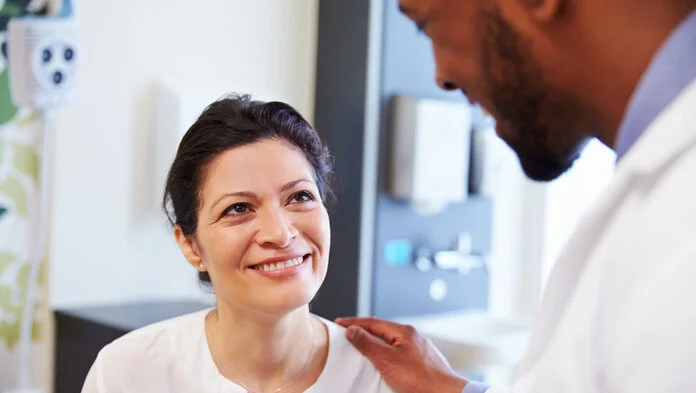 frau-arzt-freude-gute-nachricht, © Thinkstock Ein Arzt legt die Hand auf die Schulter einer glücklich lächelnden Patientin.