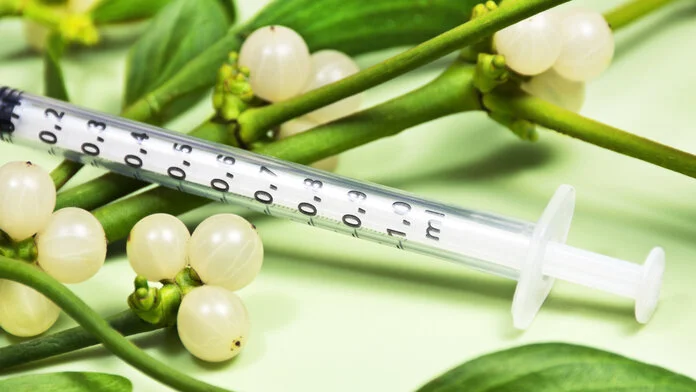 Misteltherapie, © PhotoSGH, Shutterstock Foto von Mistel-Zweigen mit Beeren und einer Spritze.