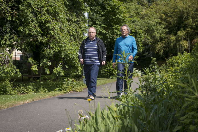 Spaziergang in der Natur, © Krebsinformationsdienst, DKFZ; Foto: Tobias Schwerdt Zwei ältere Männer gehen spazieren.