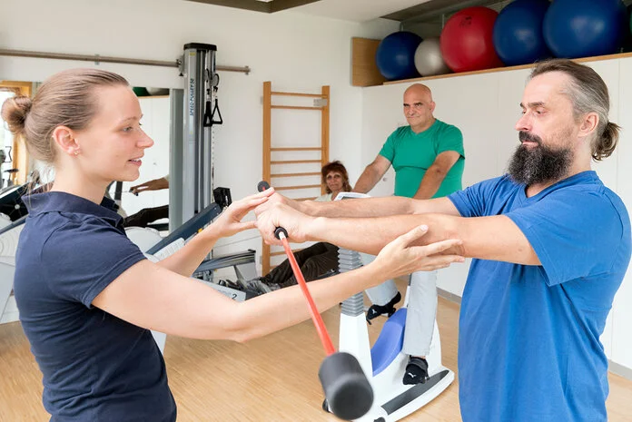 Physiotherapie, Krebsinformationsdienst, Deutsches Krebsforschungszentrum Ein Mann macht Sport mit einer jungen Physiotherapeutin.
