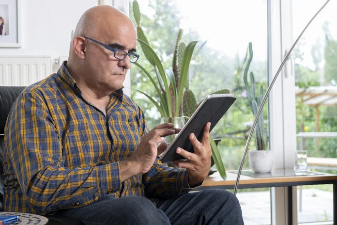 Ein Mann schaut auf den Bildschirm eines Tablets.